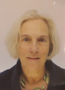 Head and shoulders photo of a female with light coloured bobbed hair and a dark jacket