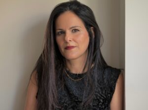 Portrait photo of female with long dark hair and black vest top