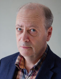 Portrait photo of gentleman with suit jacket and checked shirt